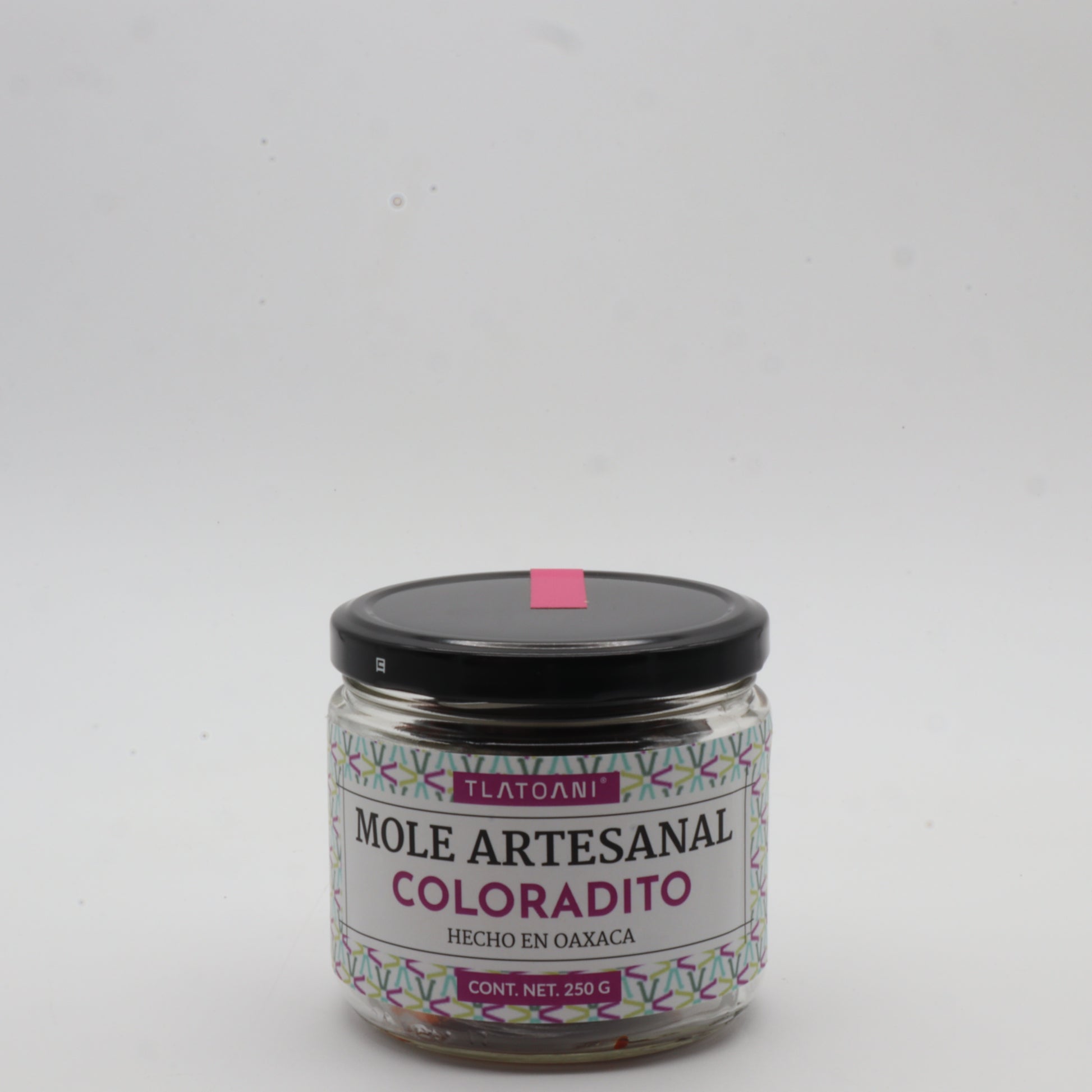Frasco de mole artesanal coloradito Tlatoani de 250g, hecho en Oaxaca, con tapa negra y etiqueta color magenta sobre fondo blanco.
